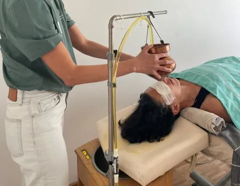 Ayurvedic Shirodhara oil treatment on forehead