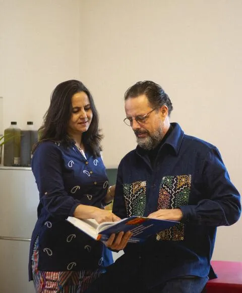 Two medical practitioners discussing a book in a serene clinic setting.