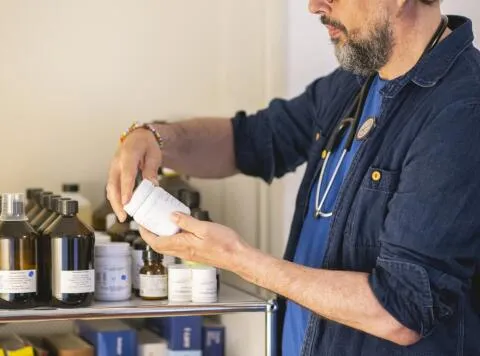 Doctor inspecting herbal medicine bottle